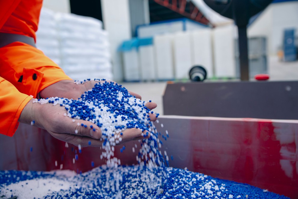 person holding recycled plastic beads